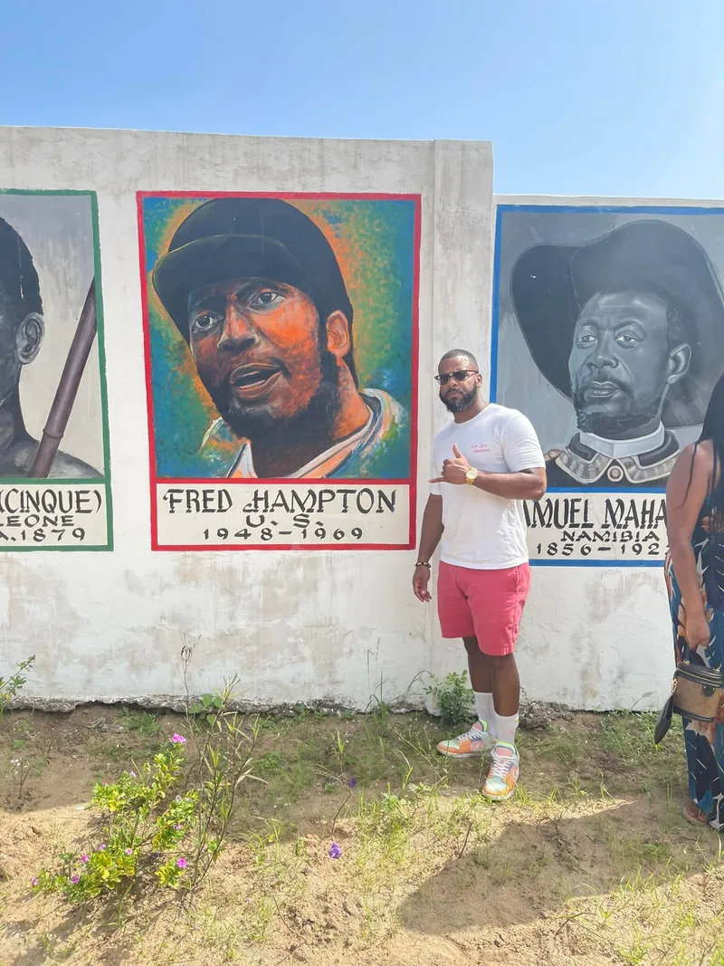 Miguel Jones beside a mural honoring Fred Hampton