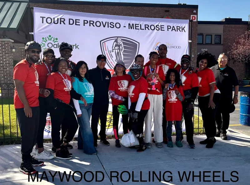 Riders in red shirts in front of the Tour De Proviso – Melrose Park banner